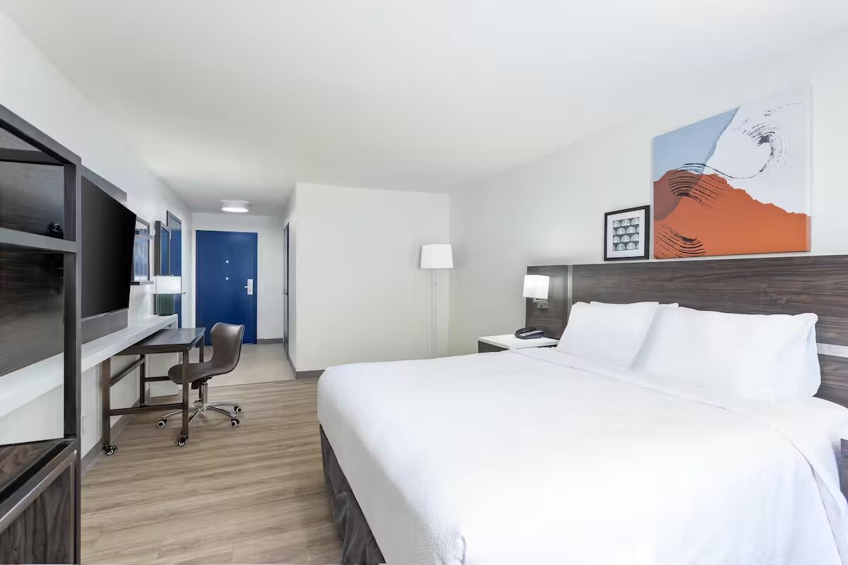 Settle into a spacious room with desk, TV, and plush bed.
