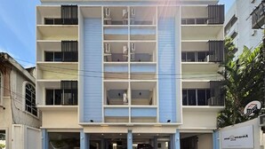 Un edificio de varios pisos con un atrio central, balcones y una entrada de garage.
