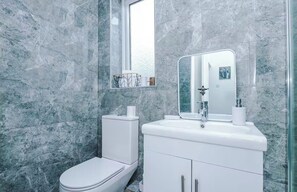 Ein Badezimmer mit Toilette, Waschbecken und Spiegel.