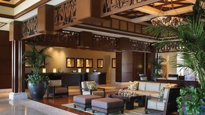 A lobby with a reception desk, seating area, and decorative elements. - Cozy 1-bedroom/living room condo with AC in charming Lahaina (Lahaina)