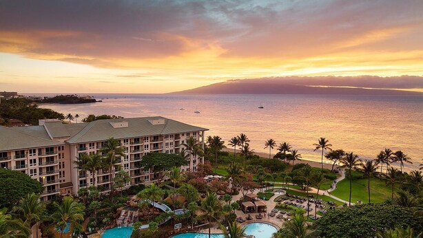 A resort with multiple swimming pools, a large building with balconies, and a view of the ocean at sunset. - Cozy 1-bedroom/living room condo with AC in charming Lahaina (Lahaina)