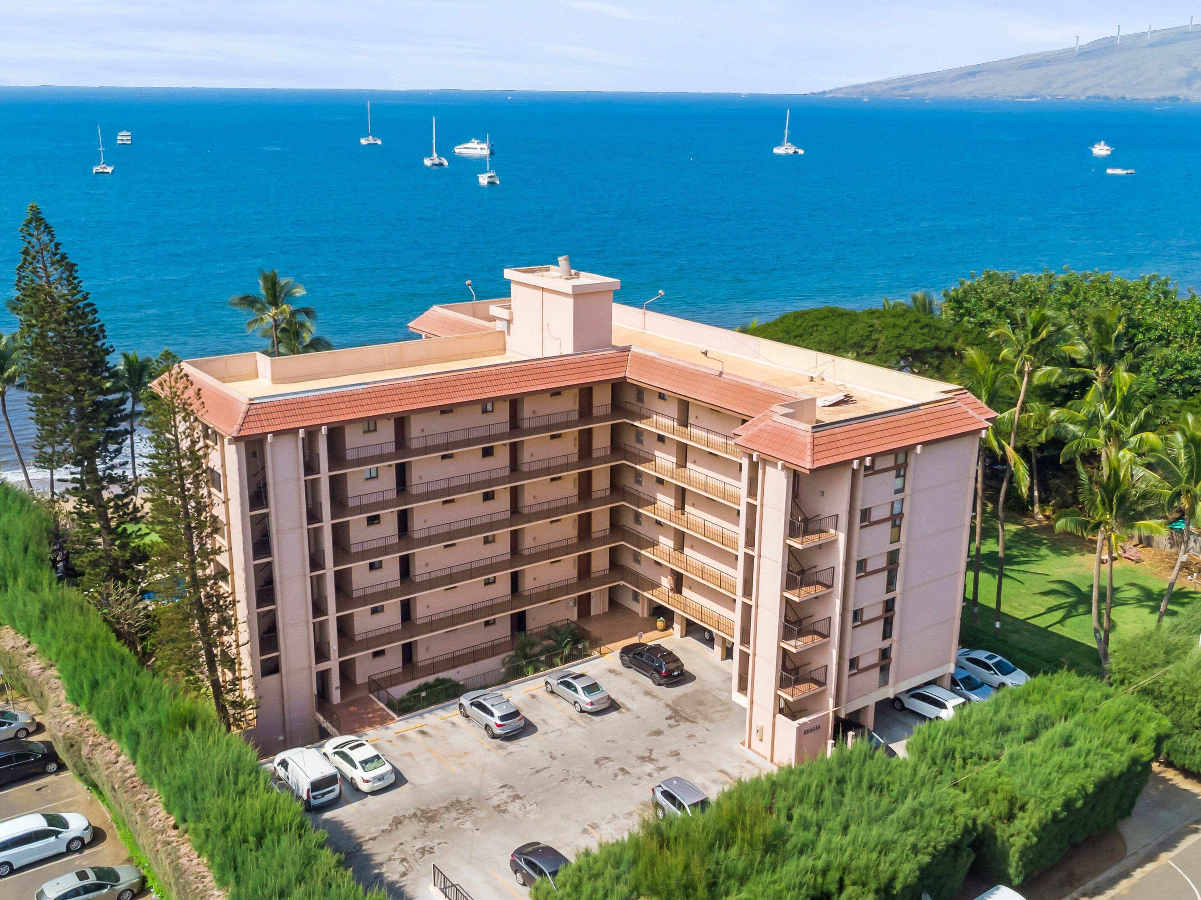 Un hotel de varios pisos con estacionamiento y vistas al océano.