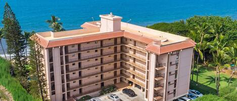 Un hotel de varios pisos con estacionamiento y vistas al océano.