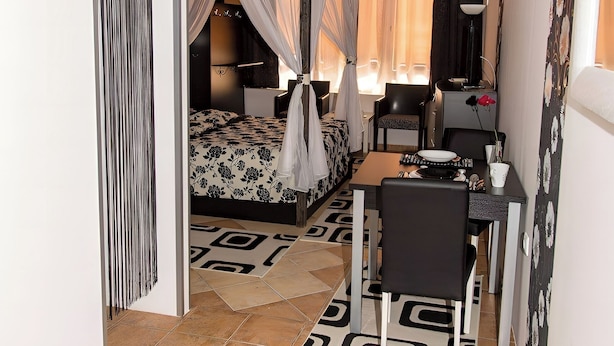 Un dormitorio con cama, mesita de noche y escritorio con silla.