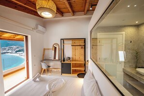 Una camera da letto moderna con una grande finestra, un soffitto in legno e vista sulla spiaggia.