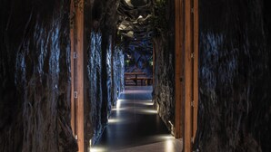 A tunnel-like passageway with wooden doors and a bench at the end. - La Rock Medellin (Medellín)