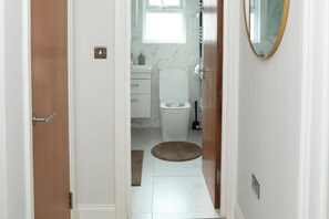 Een badkamer met een toilet, een wastafel en een spiegel.