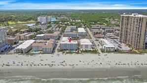 Ein Küstenhotelbereich mit mehreren Gebäuden, einem Strand und Blick auf den Ozean.