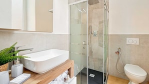 A modern bathroom with a freestanding bathtub, a glass-enclosed shower, and a toilet. - Welcome to 5 Terre Central, a newly renovated guest house located in the heart of La Spezia. Our property is the ideal starting point for those who want to explore the wonders of the Cinque Terre, easily reachable thanks to the proximity of the train sta (La Spezia)