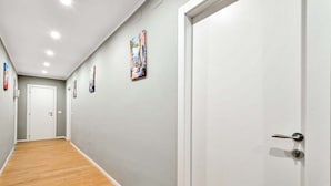 A hallway with light grey walls, wooden flooring, and white doors. - Welcome to 5 Terre Central, a newly renovated guest house located in the heart of La Spezia. Our property is the ideal starting point for those who want to explore the wonders of the Cinque Terre, easily reachable thanks to the proximity of the train sta (La Spezia)