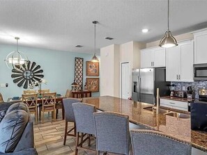 A modern kitchen with white cabinets, stainless steel appliances, and a granite countertop. - Last Minute Disney Getaway! Townhouse with Private Pool. Book Now! #15072 (Orlando)