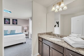 A hotel room with a bed, a large mirror, two sinks, and a nightstand with a lamp. - Last Minute Disney! Private Pool, Hot Tub, Game Room & Themed Bedrooms. Book Now! #117659 (Orlando)