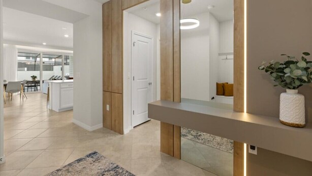 Un interior moderno con área de cocina, comedor y pasillo que conduce a una puerta.