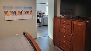 Un dormitorio con cama, cómoda de madera y televisor.