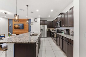 A modern kitchen with granite countertops, stainless steel appliances, and dark wood cabinets. - Last Minute Disney Getaway! Townhouse with Private Pool. Book Now! #161815 (Orlando)