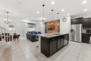 A modern kitchen with a central island, stainless steel appliances, and pendant lighting. - Last Minute Disney Getaway! Townhouse with Private Pool. Book Now! #161815 (Orlando)