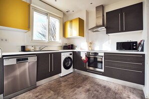 Eine moderne Küche mit Geschirrspüler, Waschmaschine, Backofen und Mikrowelle.
