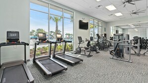A gym with treadmills, exercise bikes, and weight machines. - Last Minute Disney! Private Pool, Hot Tub, Game Room & Themed Bedrooms. Book Now! #125797 (Orlando)