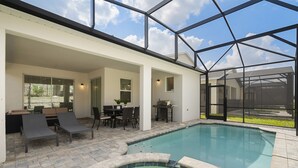 Un espace piscine extérieur moderne, doté de chaises longues, d’une table à manger et d’un jacuzzi.