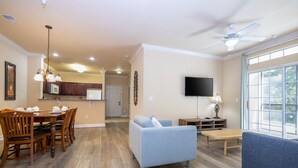 A spacious living area with a dining table, sofas, and a TV. - Last Minute Disney Getaway! Luxury Condo with Private Balcony. Book Now! #127373 (Orlando)