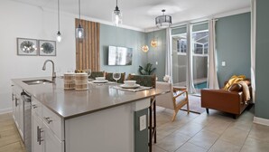 Een moderne keuken met een centraal eiland, een eetgedeelte met stoelen en een bank.