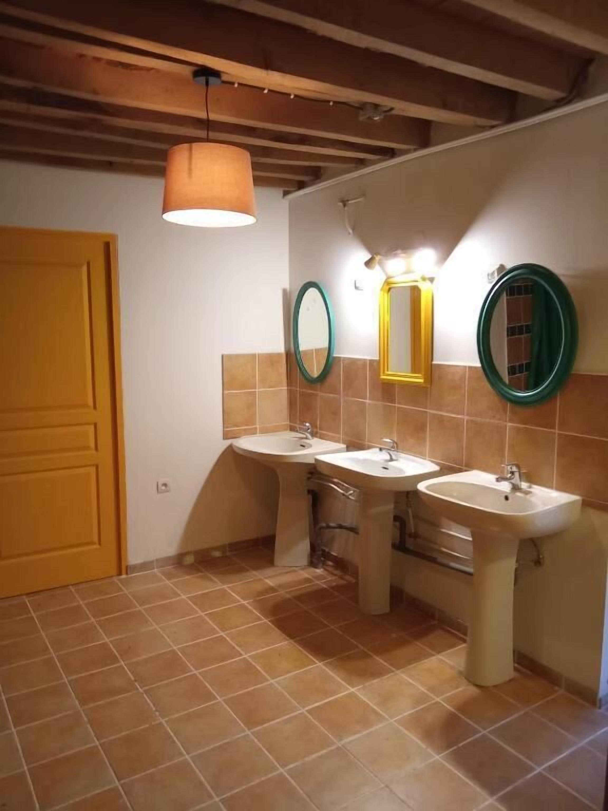 A bathroom with two sinks, a mirror, and a hanging light fixture.