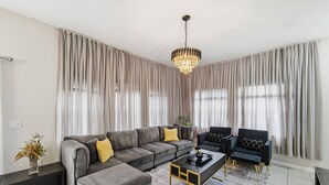 Uma sala de estar moderna com um sofá modular, uma mesa de centro e duas poltronas.