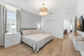 Una camera da letto moderna con un letto, comodini, una scrivania e una sedia.