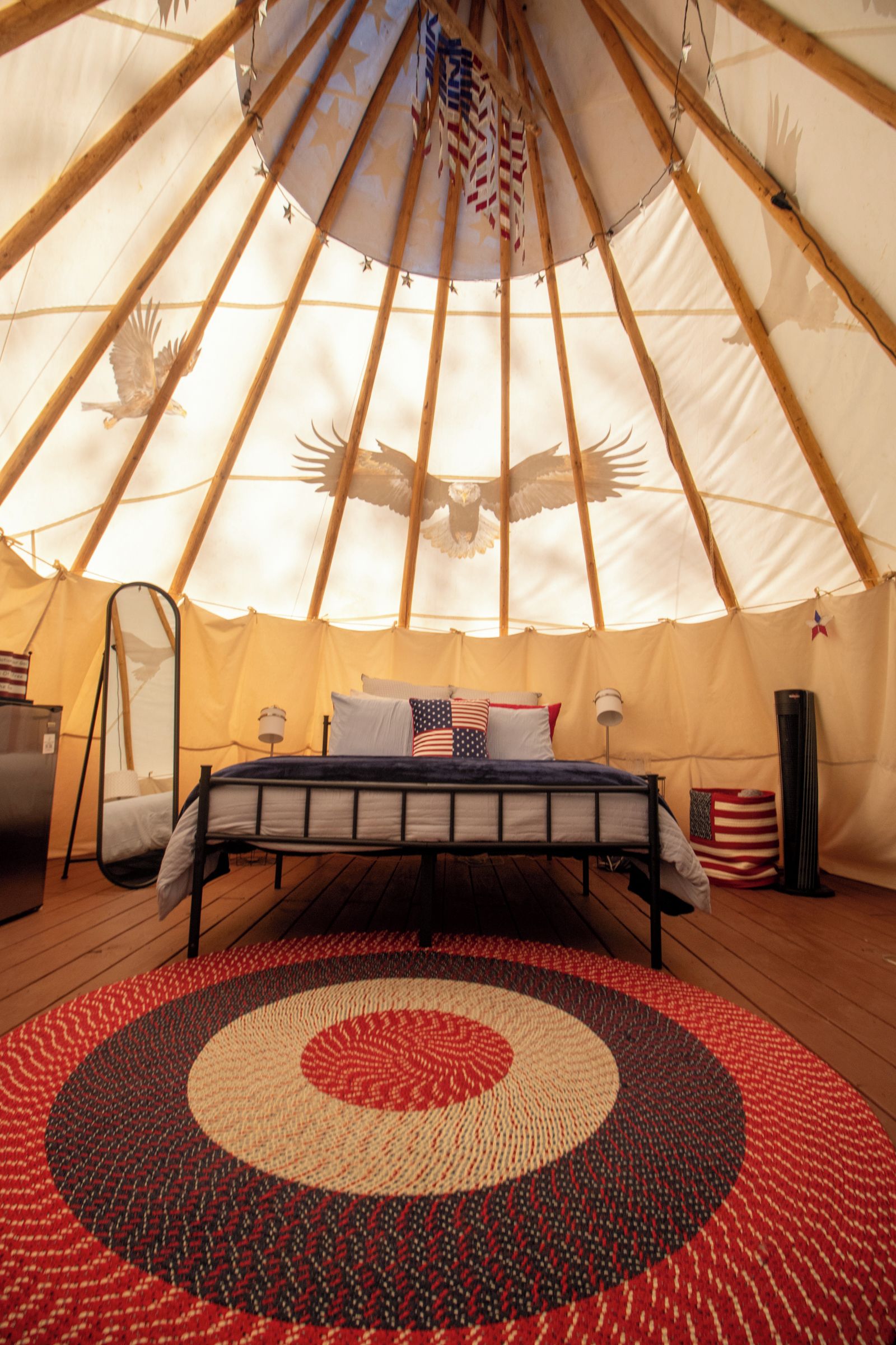 A yurt interior with a bed, pillows, and a rug.