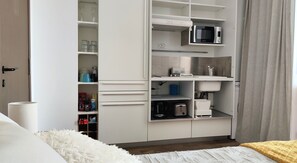 A bedroom with a bed, a white wardrobe, a microwave, and a sink. - Mango Paradise - Studio with splendid sea view, sunrise and sunset! (SAINT-FRANCOIS)