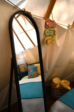 A tent with a bed, a ladder, and a wall with hanging signs. - Flip Flop Stop Teepee at The Edge—Unique Riverfront Glamping in Salt Lick, KY (Salt Lick)