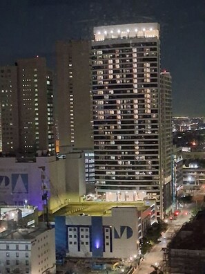 Ein Hochhaus mit mehreren Stockwerken, beleuchteten Fenstern und einer auffälligen Beschilderung an der Seite.