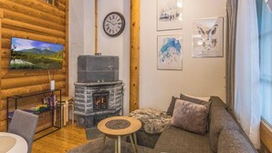 A cozy living room with a stone fireplace, a mounted TV, and artwork on the walls. - Levin ainola by Interhome (Kittilä)