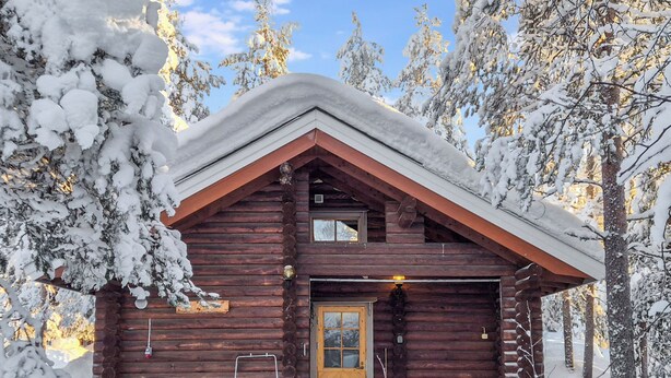 A log cabin with a wooden door, a garage, and a small porch area. - Levin ainola by Interhome (Kittilä)