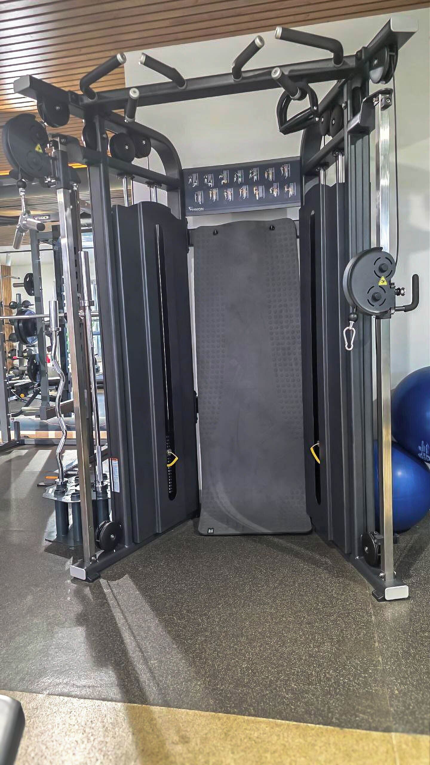 A gym with a squat rack, weight bench, and various exercise equipment.