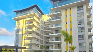 Un hôtel moderne à plusieurs étages, doté d’une piscine et de pelouses verdoyantes.