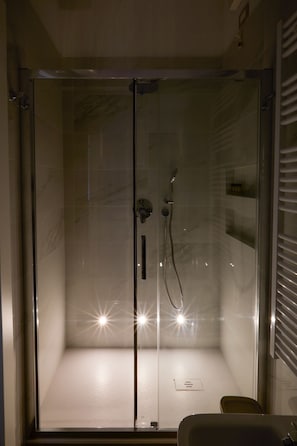A glass-enclosed shower with a handheld showerhead and a wall-mounted faucet. - Mia House 2, two-room apartment between San Siro and City Life, near old and new fairgrounds (Milano)