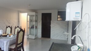 A compact kitchen with a dining area, a built-in refrigerator, and a glass-fronted cabinet. - Boaventura  (Unaí)