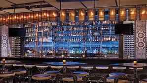 A bar area with multiple shelves of liquor bottles, a television, and bar stools. - Spacious, luxury villa at 5-star Westin Riverfront. Best pool, spa, fitness,etc! (Avon)