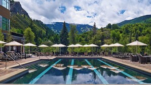 A pool area with lounge chairs and umbrellas, surrounded by mountains and trees. - Spacious, luxury villa at 5-star Westin Riverfront. Best pool, spa, fitness,etc! (Avon)