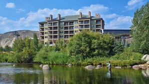 A multi-story hotel with balconies, a river in front, and a mountain in the background. - Spacious, luxury villa at 5-star Westin Riverfront. Best pool, spa, fitness,etc! (Avon)