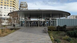 Een modern gebouw met een gebogen entree, een loket en een pad er naartoe.