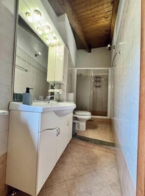 A modern bathroom with a vanity, mirror, and shower. - COURSE RESIDENCE (Vercelli)