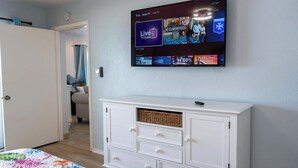 A room with a flat-screen TV mounted on the wall displaying a TV guide. - Bayfront w-docks & fish 3 Patios  Prime Location (South Padre Island)