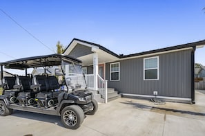 Un bâtiment moderne à deux étages, doté d’un porche abrité et d’un véhicule de golf garé devant.