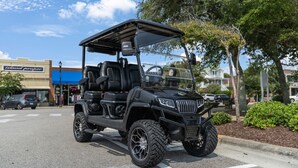 A black golf cart parked on a street with a building labeled "Island proper" in the background. - 4 Seat Golf Cart~Family Friendly~Near DT Beaufort! (Beaufort)