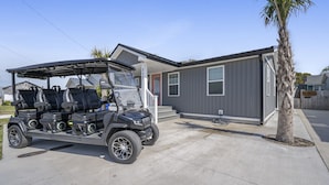 A modern two-story building with a covered area for a golf cart. - 6 Seat Golf Cart~Family Friendly~Near DT Beaufort! (Beaufort)