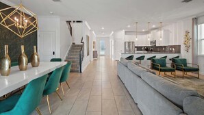 Ein modernes Interieur mit Essbereich, Treppe und Küche.