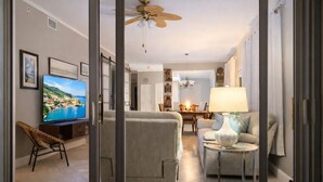 Una sala moderna con televisor, sofá y comedor.