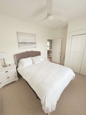 A bedroom with a bed, nightstand, and a ceiling fan. - The Magnolia - 37 Butternut (Prince Edward)